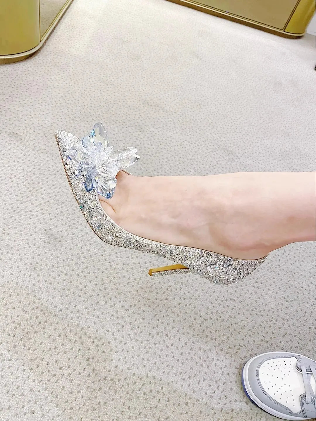 Sparkly high-heeled shoe with crystal embellishments on a light background