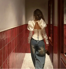 Person walking down a hallway with red tiled walls and white ceiling.