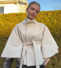 Beige stand collar belted cape coat detail