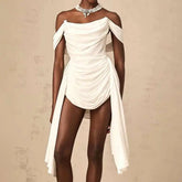 White one-shoulder dress with flowing fabric on a neutral background