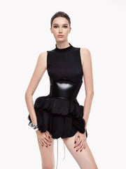 Black sleeveless turtleneck dress with a glossy bodice and voluminous ruffled mini skirt.