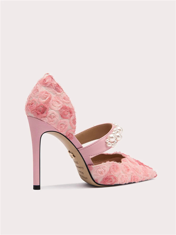 Pink high-heeled shoes with floral design on a light gray background