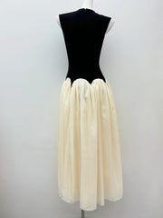 Mannequin wearing a black top and cream skirt against a white background
