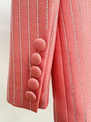Close-up of a pink textured fabric with decorative buttons and white stripes on a light background