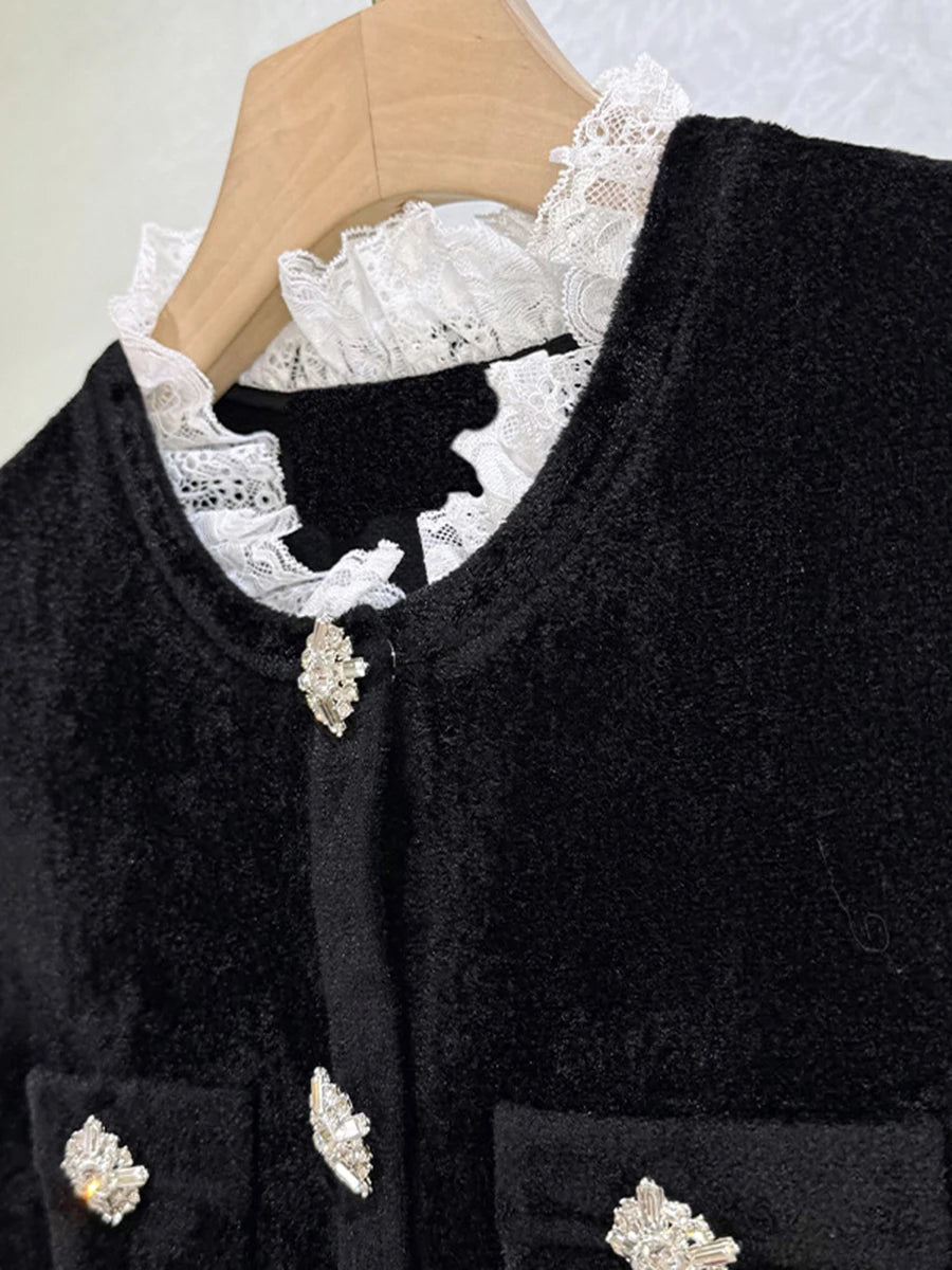 Black cardigan with white lace collar and decorative buttons on a hanger.