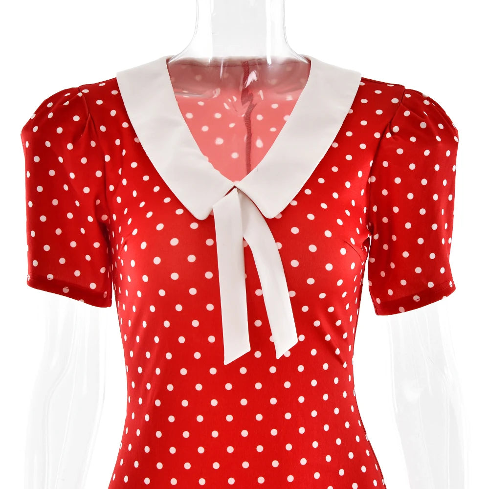 Red polka dot blouse with white collar and tie on a mannequin against a white background