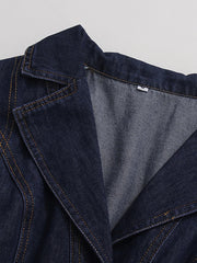 Close-up of a dark blue denim jacket with a visible brand tag on a light gray background