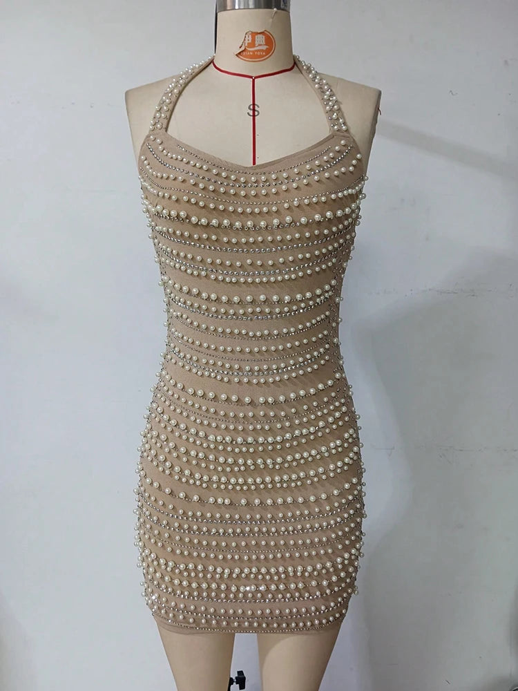 Beige dress with pearl embellishments on a mannequin against a white background