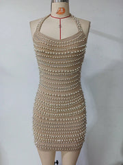 Beige dress with pearl embellishments on a mannequin against a white background
