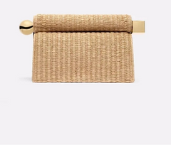 Woven towel holder with gold accents on a white background