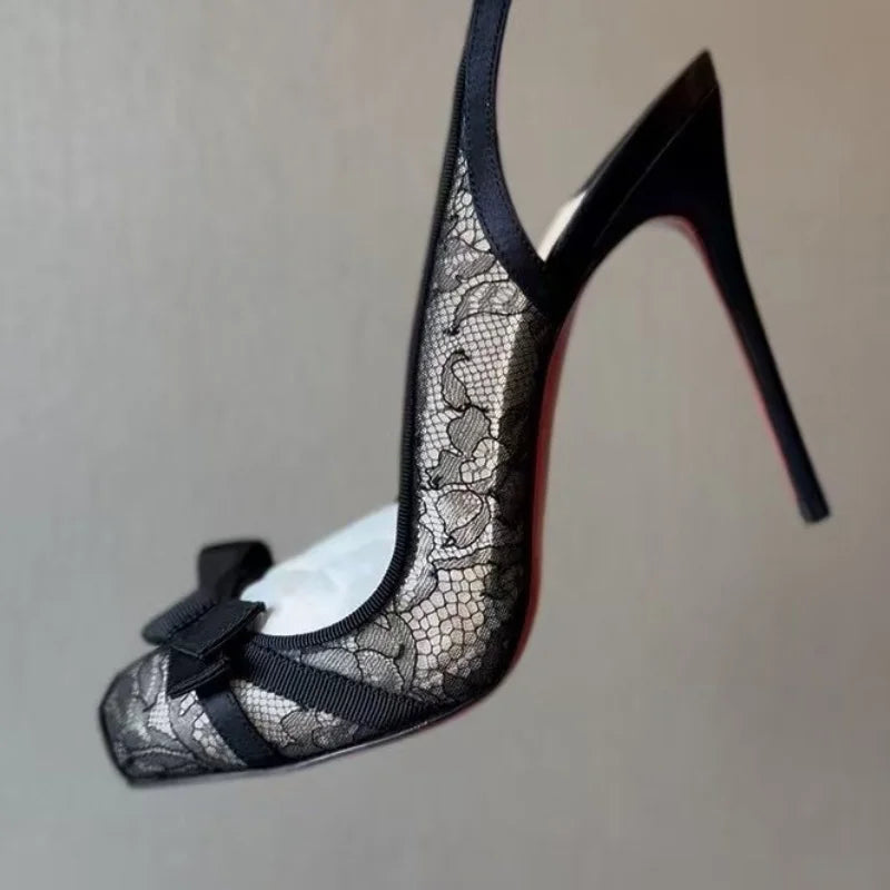 Close-up of black lace slingback heel with bow detail