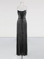 Black sequin evening gown on a mannequin against a white background