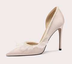 Beige high-heeled shoe with lace details on a light gray background