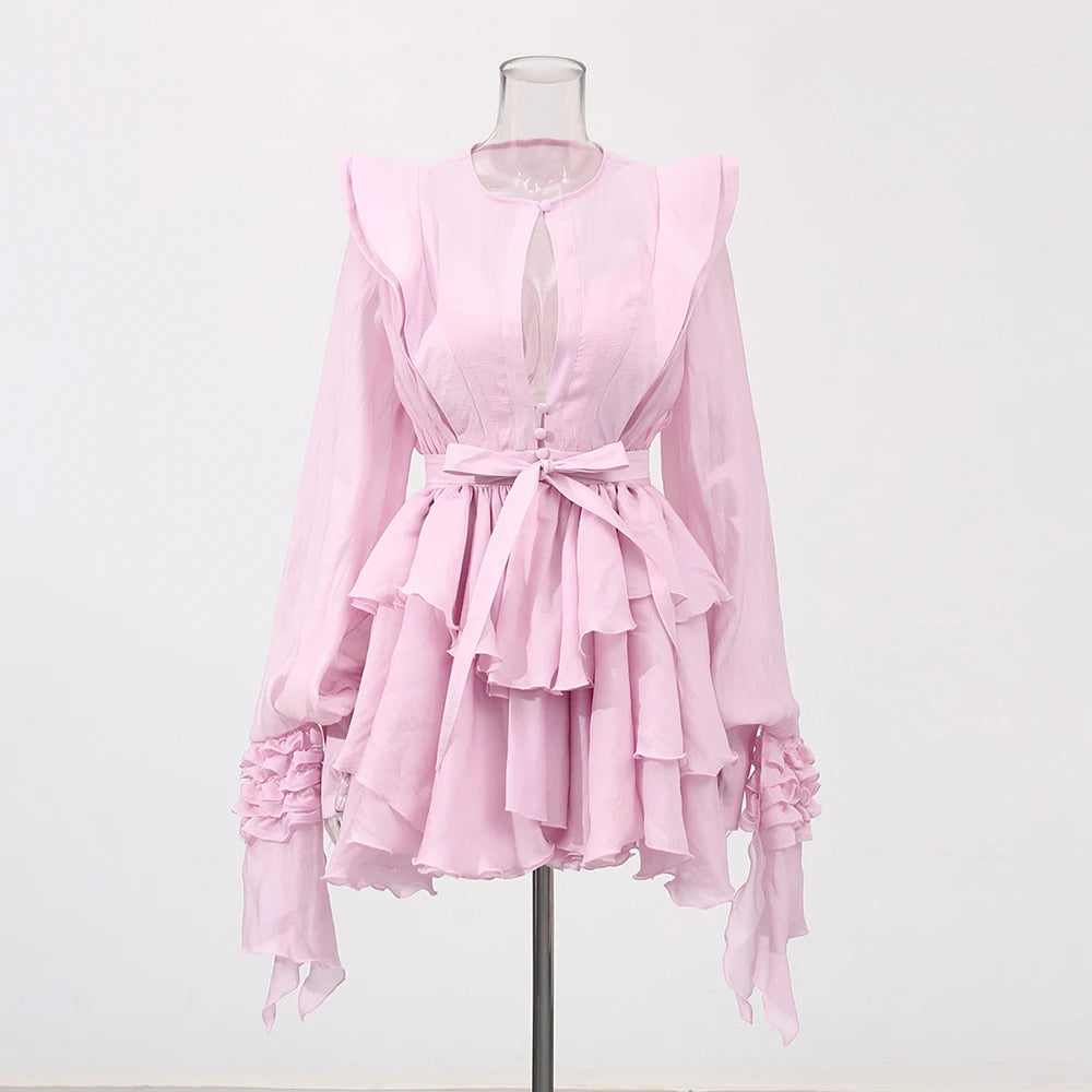 Pink ruffled blouse on a mannequin against a white background