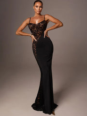 Woman wearing a black lace evening gown against a gray background