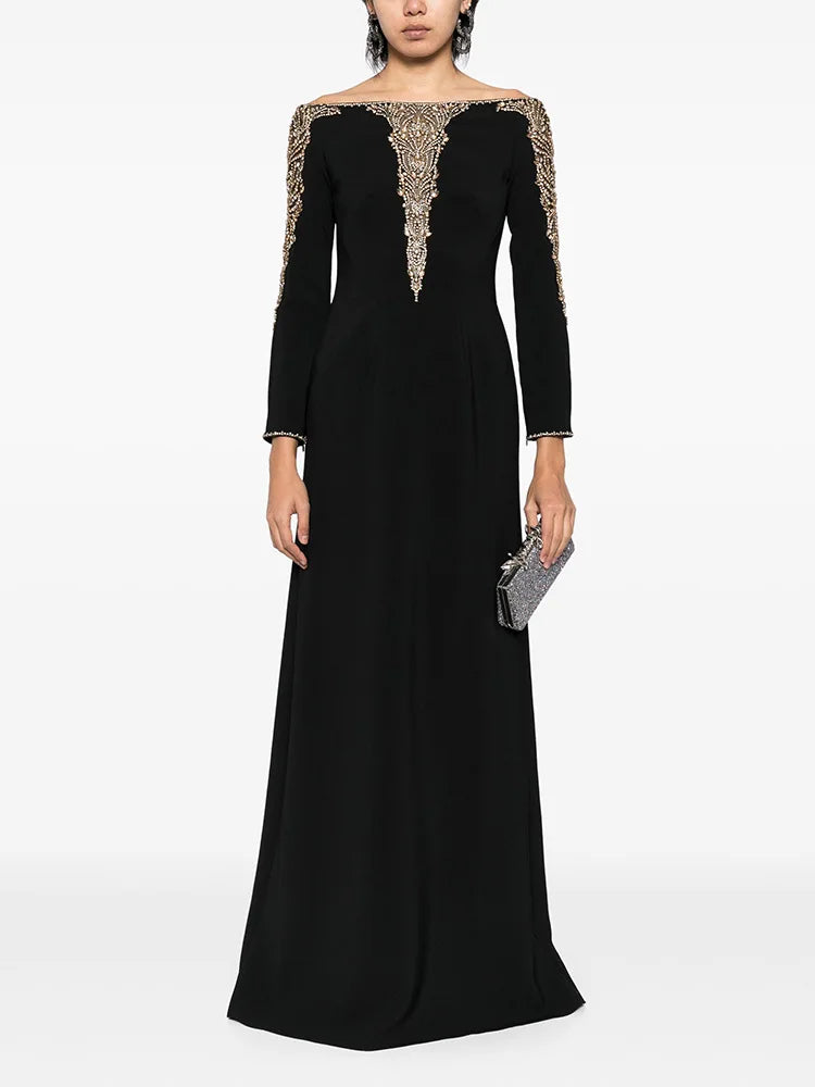 Black long sleeve maxi dress with beaded neckline and cuffs worn by a model.