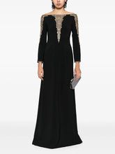 Black long sleeve maxi dress with beaded neckline and cuffs worn by a model.