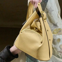 Yellow handbag held by a person with a blurred background