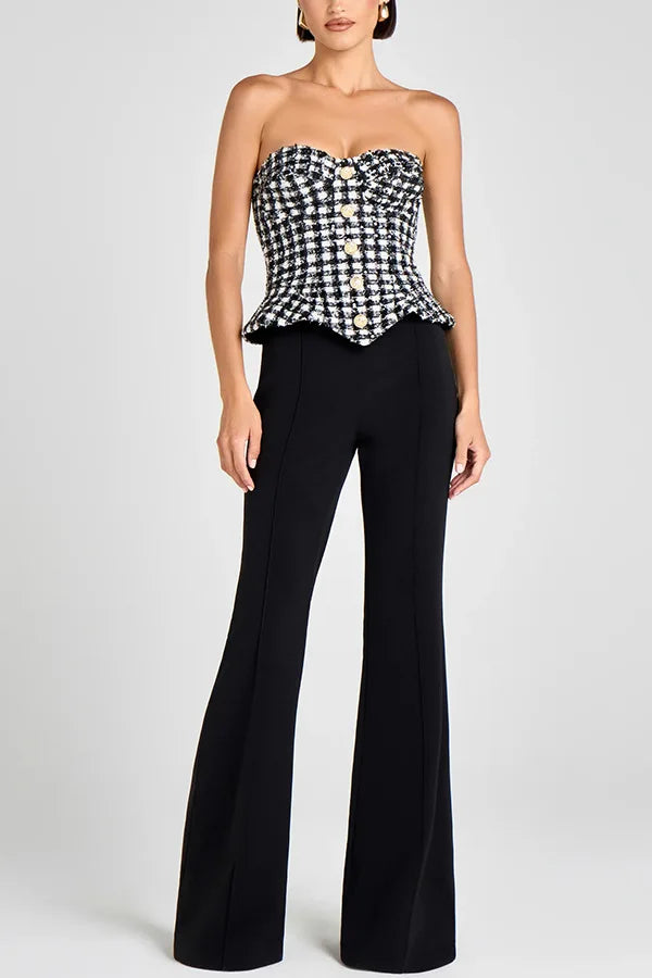 Woman wearing a black and white checkered top and black flared pants on a light gray background