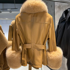 Beige coat with fur trim hanging on a rack.
