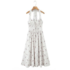 White floral dress on a wooden hanger against a white background