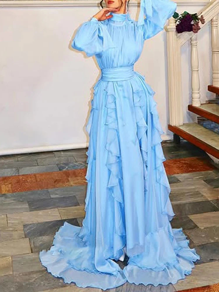 Light blue evening gown with ruffled layers on a stone floor.