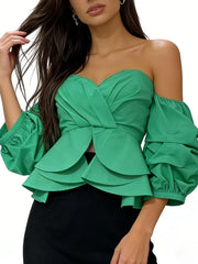 Green off-shoulder top with ruffled details on a white background