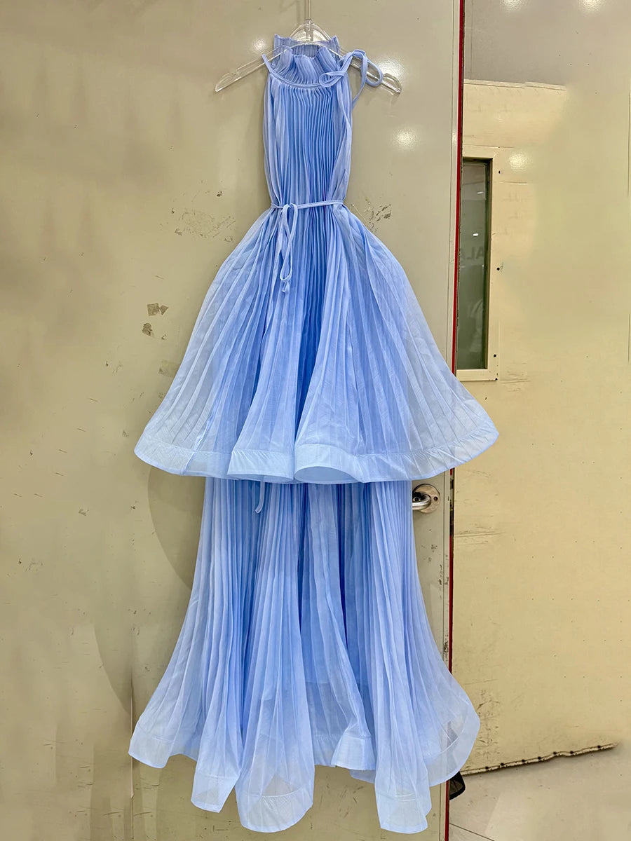 Light blue dress hanging on a hanger against a beige wall.
