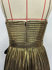 Mannequin wearing a gold pleated dress against a white background