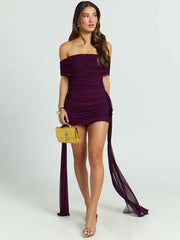 Woman wearing a burgundy off-shoulder dress with a yellow handbag on a white background