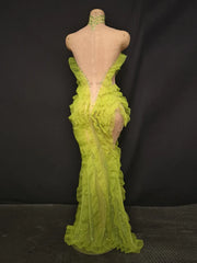 Green evening gown on a mannequin against a black background