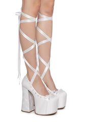 White platform shoes with lace-up design on a white background