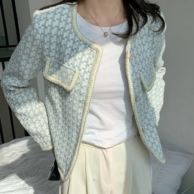 Person wearing a light blue patterned jacket over a white shirt and beige pants.