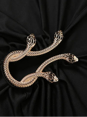 Gold snake-shaped brooch on black fabric
