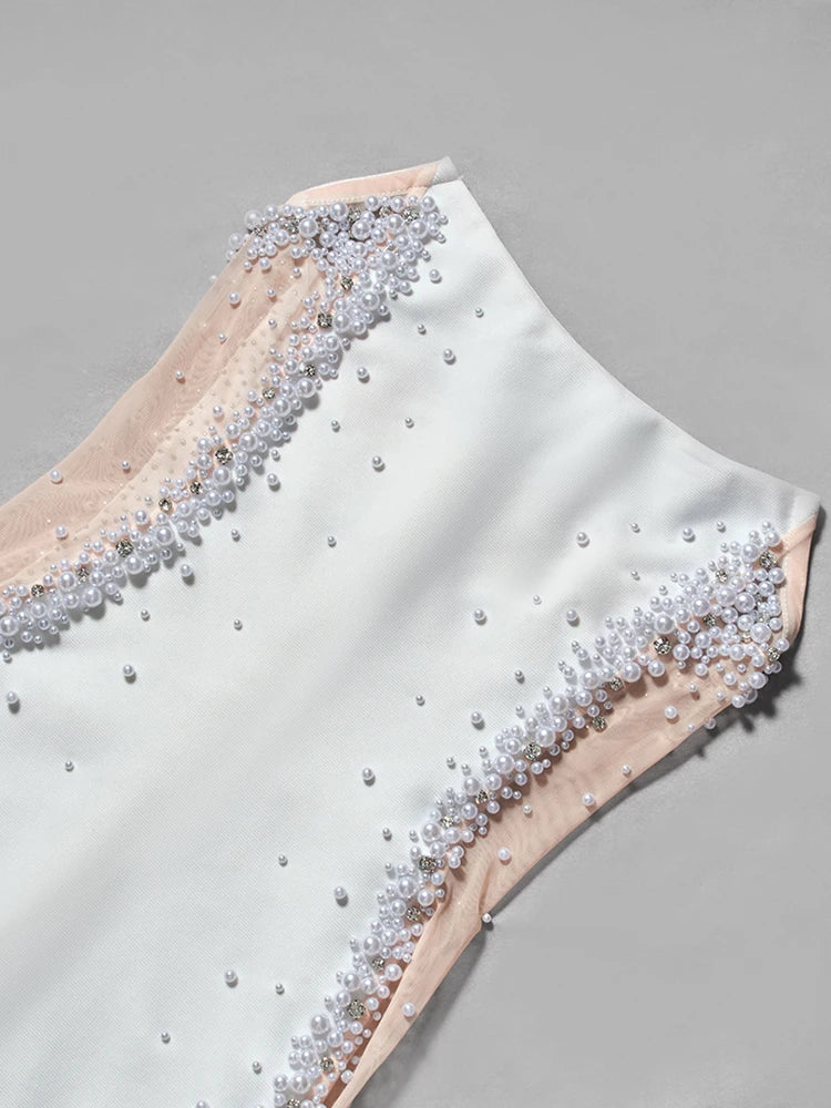 Close-up of a garment with pearl and crystal embellishments on a gray background