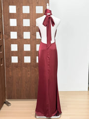 Maroon evening gown on a mannequin against a wooden panel background