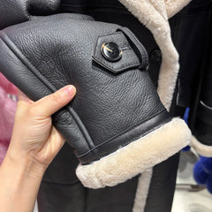 Black leather boot with white fur lining held by a hand