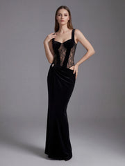 Woman wearing a black evening gown with sheer lace details on a gray background