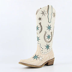 White cowboy boot with star and horseshoe patterns on a light gray background