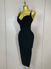 Black dress with bead detailing on a mannequin against a white background