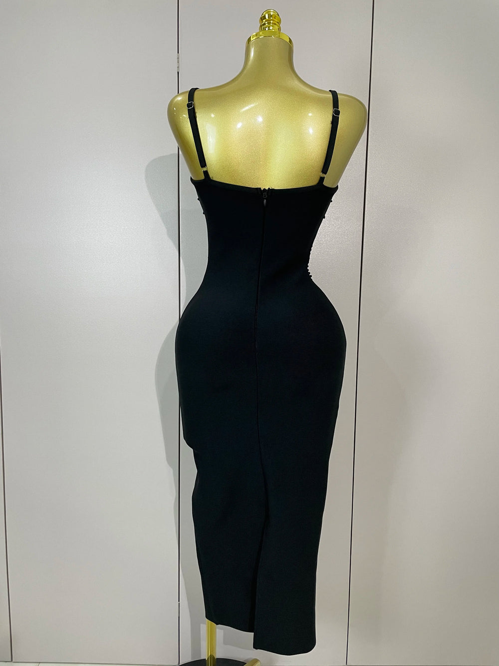 Black dress on a mannequin against a white wall