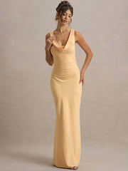Woman wearing a yellow evening gown against a plain background