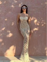 Woman wearing a patterned dress against a textured wall.