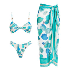 White bikini top and bottom with abstract blue and green dots, and a matching wrap skirt.
