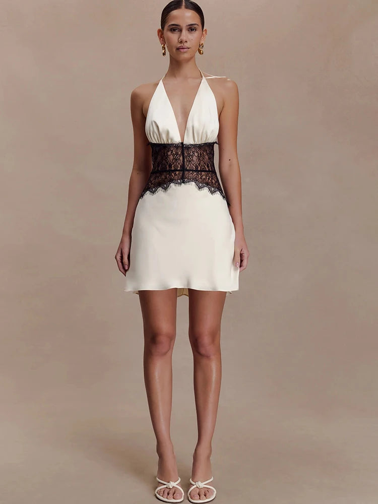 Full body shot of model wearing white halter neck mini dress