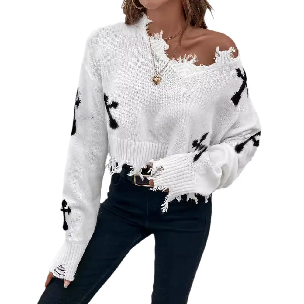 White sweater with black abstract patterns worn by a person on a white background