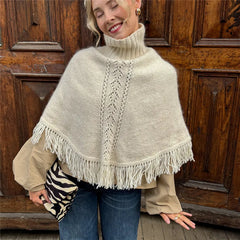 Beige knit poncho with turtleneck, lace detail, and fringe