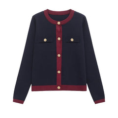 Navy blue cardigan with red trim and gold buttons on a white background