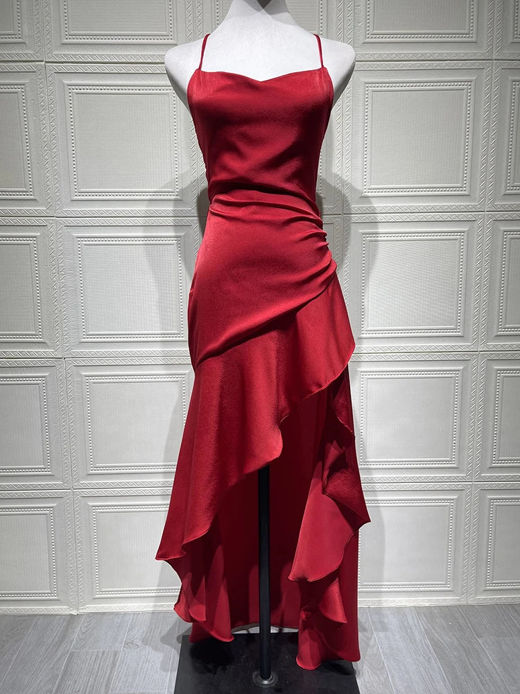 Red satin dress on a mannequin against a white paneled wall.