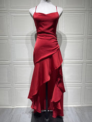 Red satin dress on a mannequin against a white paneled wall.